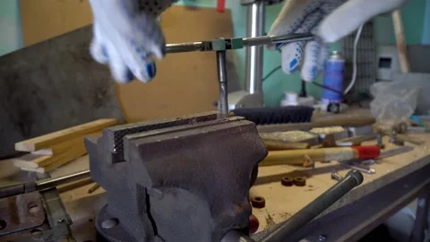Close up worker cuts the damaged thread of a nut bolt clamped in a vise. Steel Stock Footage 234907847