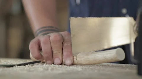 Close-up. a worker cuts off a wooden stick with a japanese hand saw Stock Footage 140323346