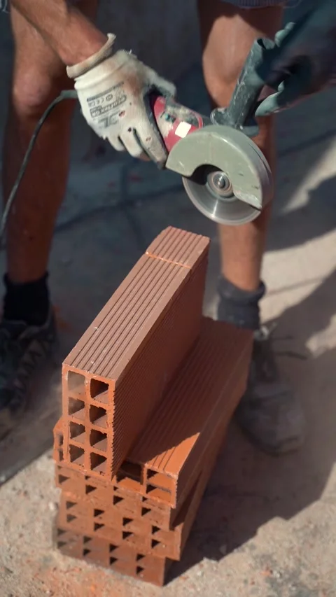Close up of a worker cutting a brick with an electric radial saw. Upright v.. Stock Footage 242036446