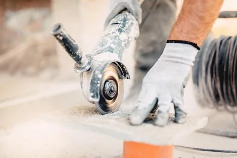 Close-up of worker cutting stone with grinder. Dust while grinding stone Stock Photos