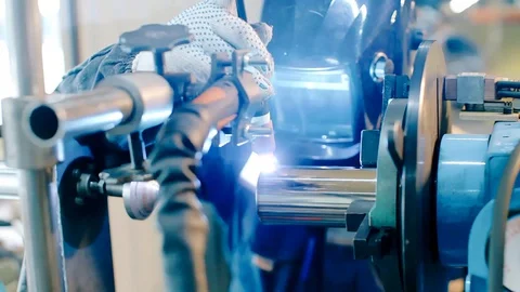 Close up: worker in face shield or protective mask uses gas welding on lathe Stock Footage 130032587