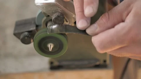 Close-up. a worker grinds a homemade chisel from a bearing using goi paste. m Stock Footage 140323344