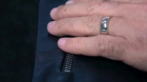 Close-Up Worker Hand Attaching Zipper to Leather Jacket During Factory Assembly Stock Footage 322057730