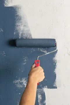 Close up of a worker hand holding paint roller. House renovation process with Stock Photos