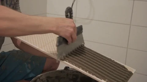 Close-up of worker hand Man working in bathroom, doing repair tile Video stock 78684790