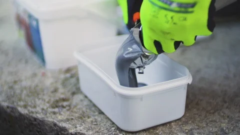 Close up of worker hand squeezing protection primer to a plastic pot. Stock Footage 116687527