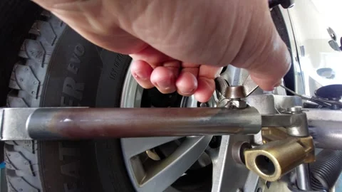 Close-up of worker hand tightening a wing nut on a wheel alignment tool or mecha Видео 338286779