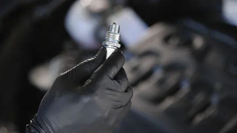 Close up of worker hands changes spark plugs in car engine in auto service. An Stock Footage 203556178