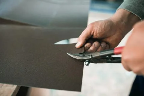 Close up of a Worker hands use scissors to cut the metal sheet Stock Photos