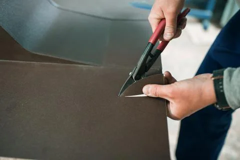 Close up of a Worker hands use scissors to cut the metal sheet. Stock Photos