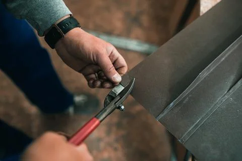 Close up of a Worker hands use scissors to cut the metal sheet Stock Photos
