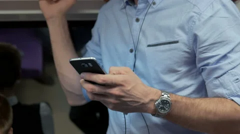 Close-up of worker holding a cell phone during his daily commute Stock Footage 67261296