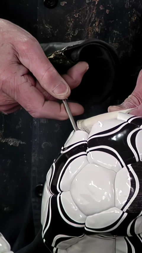 Close-Up of Worker Inserting Air Bladder in Soccer Ball - Vertical Video Stock Footage 292853958