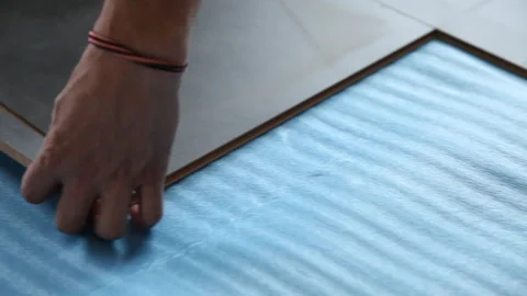 Close up of a worker installing a floor with a mallet Stock Footage 232398161