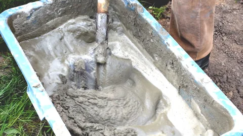 Close up worker mans hands in gloves mixing, stirring cement slurry, concrete Stock Footage 280004194