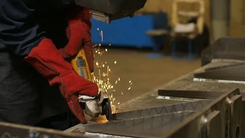 Close up of worker in mask use angle grinderon metal construction metal. Sparks Video stock 72697883