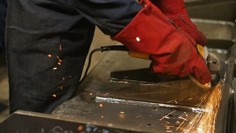 Close up of worker in mask use angle grinderon metal construction metal. Sparks Stock Footage 72698170
