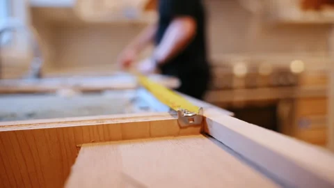 Close up of a worker measuring cabinet frame with a tape measure during kitchen Stock Footage 332185905