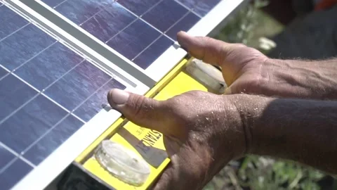 Close up of a worker measuring the space between two solar panels Stock Footage 160811147