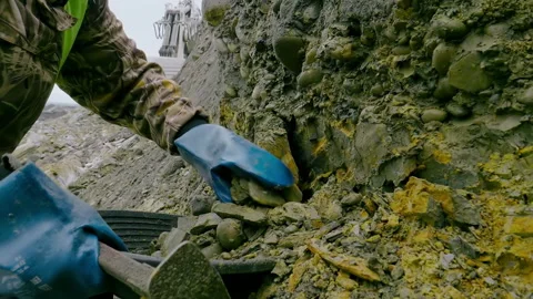 Close-up of a worker mining the material from the natural rock formation Stock Footage 304715733