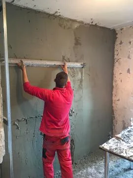 Close-up of a worker plastering a wall with cement Stock Photos