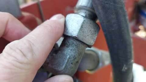 Close up of a worker pointing at a high pressure hydraulic hose connection fitti Stock Footage 336006970