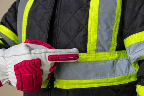 Close-up of a worker pointing at reflective tape on a high visibility jacket  Stock Photos