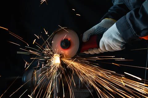 Close-up of a worker in protective gloves cutting a metal bar Photos