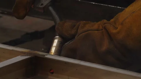Close-up of worker in protective uniform welding steel structures and components Stock Footage 202048985