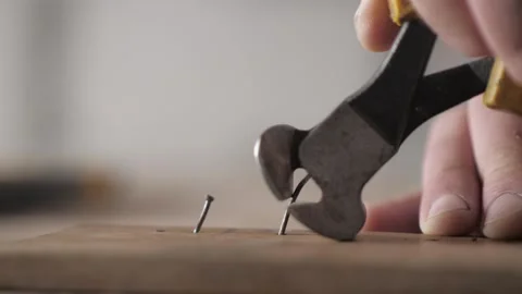 Close-up. a worker pulls a nail out of a piece of wood using pliers Stock Footage 155860974