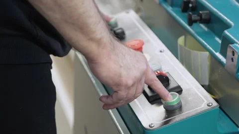 Close up of worker pushing start button on a machine in a workshop Stock Footage 302473359