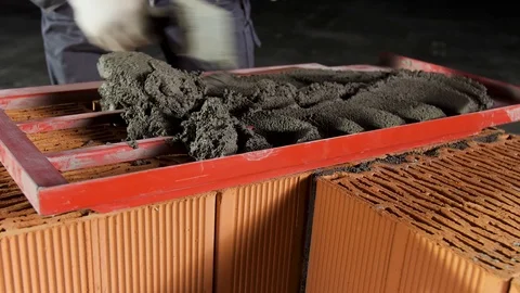 Close up of a worker putting mortar into the wooden frame to make a layer on the Vídeo Stock 123769198