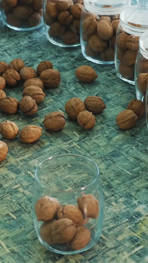 Close-up, worker s hands put walnuts in glass jars. different kinds, grown Stock Footage 323082732
