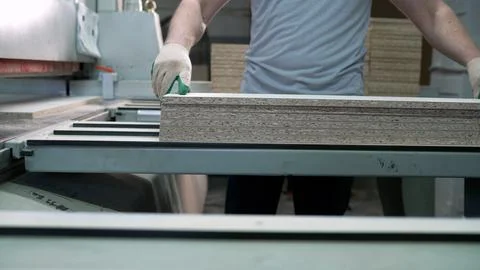 Close up of worker in safety gloves moving stack of laminated chipboard panels Stock Photos
