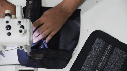Close up of worker sewing leather piece in indoor factory, Kalkata, India Stock Footage 145037217