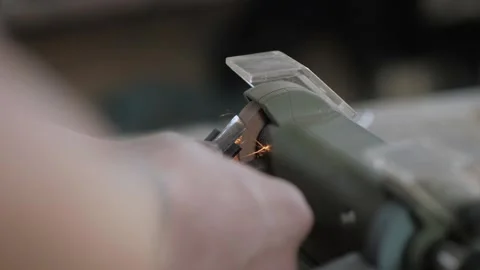 Close-up. a worker sharpens a homemade chisel from a bearing on an electric g Stock Footage 140323317