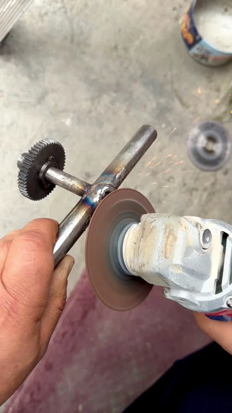 Close-up of a worker using an angle grinder to smooth a welded metal joint o Video stock 333381092