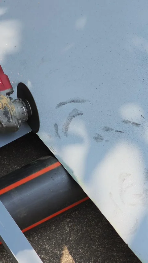 Close up of worker using angle grinder to cut steel plate with flying sparks. Video stock 333392200