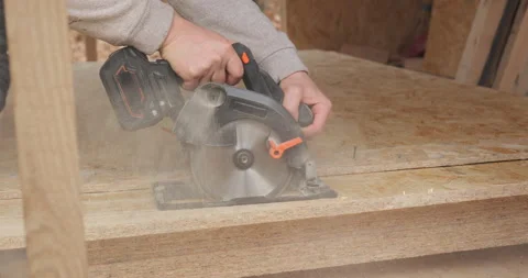 Close-up of a worker using a circular saw to cut plywood Stock Footage 231238547