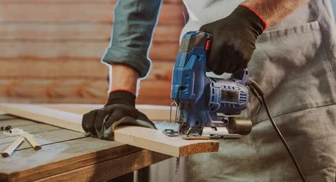 Close up of worker using electric jigsaw in the workshop Stock Photos