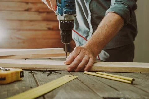 Close up of worker using electric scredriver on the table Stock Photos