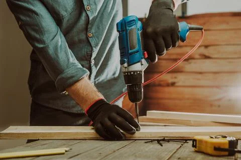 Close up of worker using electric scredriver on the table Stock Photos