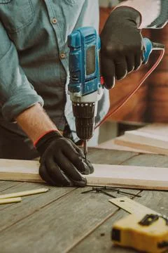 Close up of worker using electric scredriver on the table Stock Photos