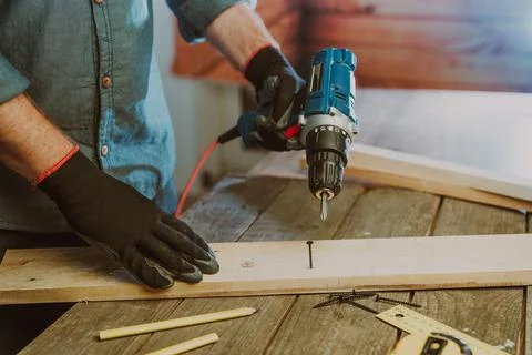 Close up of worker using electric scredriver on the table Stock Photos
