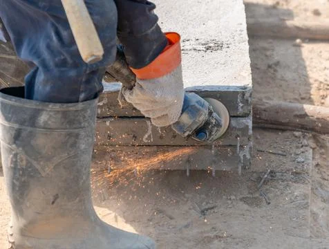 Close up worker is using grinder for cutting reinforcing steel. Stock Photos