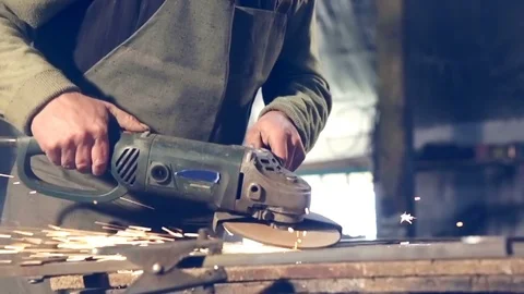 Close-up worker using industrial grinder on metal rail track parts in industrial Stockbeeldmateriaal 77032923