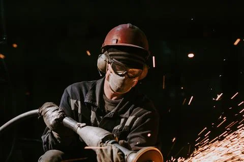 A Close-Up Of A Worker Using A Metal Grinder Stock Photos