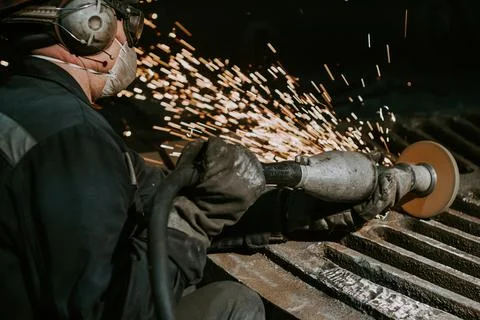 A Close-Up Of A Worker Using A Metal Grinder Stock Photos