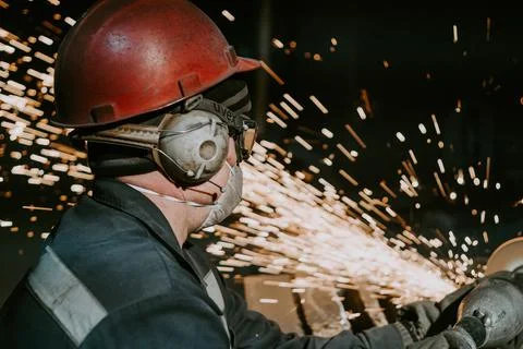 A Close-Up Of A Worker Using A Metal Grinder Stock Photos