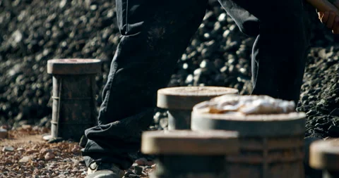 Close up of worker using shovel to move dark gravel at construction site Video stock 329564354